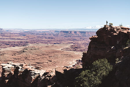 person standing on cliff during daytime thumbnail