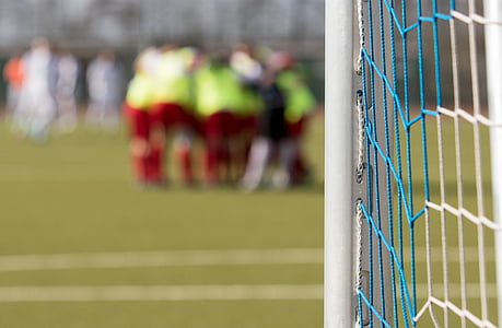 preparing soccer team standing near goal net in sports arena during daytime thumbnail