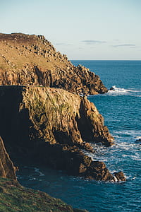 brown rock cliff beside sea thumbnail