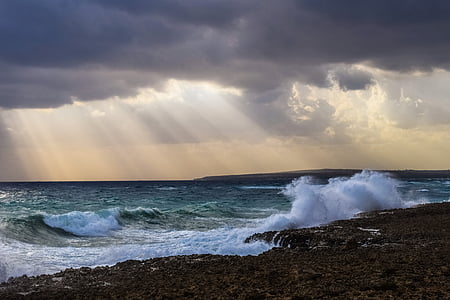 photo of wavy ocean under crepuscular rays thumbnail