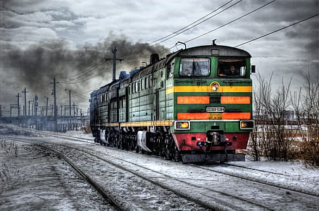 green and orange locomotive taken during daytime thumbnail