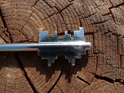 gray stainless steel key on brown wood thumbnail