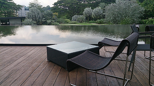 black patio chairs beside body of water thumbnail
