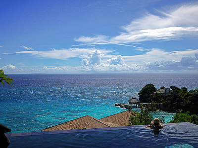person in pool near beach under blue sky and white clouds at daytime thumbnail