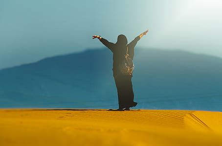 woman in black dress raising both arms thumbnail