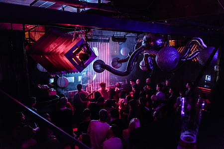 group of people inside black and red concrete building interior with lights thumbnail