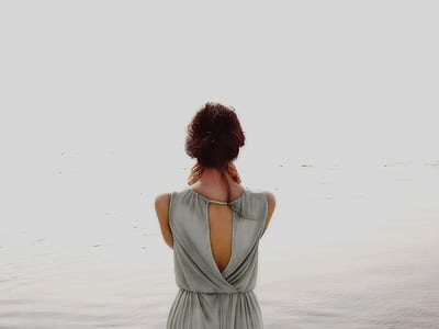 photo of woman facing body of water wearing gray top thumbnail