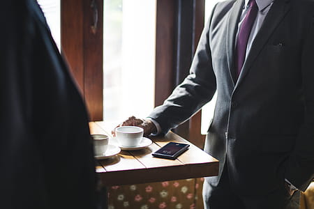 Two Men Standing Beside Table Near Wall thumbnail