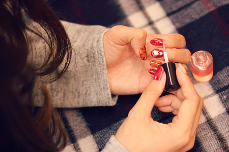 woman putting red nail polish thumbnail