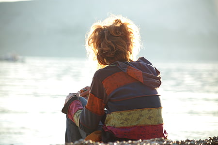 girl sitting beside body of water thumbnail