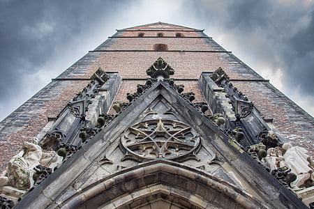 brown brick tower under cloudy sky thumbnail