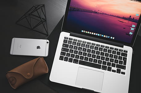 turned-on space gray MacBook beside silver iPhone 6s thumbnail