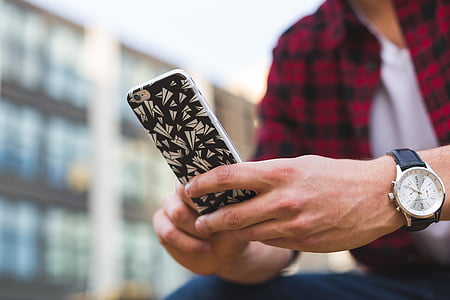 person holding gold iPhone 7 with black and white case thumbnail