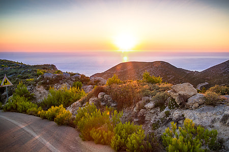 landscape photo of wide ocean plants and mountains during sunset thumbnail