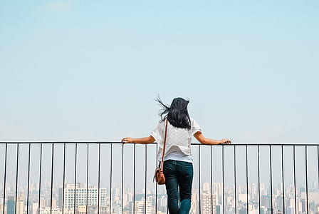 woman holding on railings during daytime thumbnail