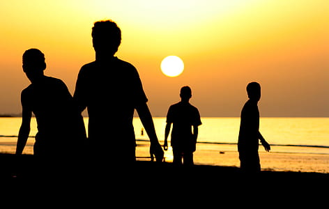 Silhouette of 4 People Near Ocean during Sunset thumbnail