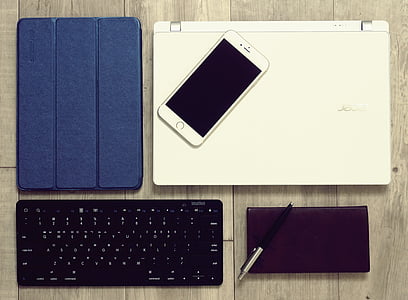 gold iPhone 6 beside leather iPad case and wireless keyboard thumbnail