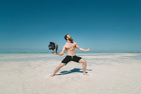 man holding gray and black LED light on desert thumbnail