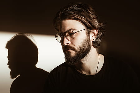 man wearing eyeglasses near wall with shadow thumbnail