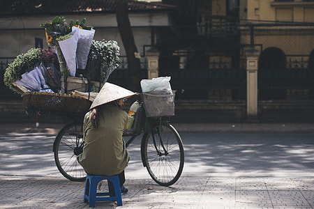 person sitting on blue chair infront by bicycle thumbnail
