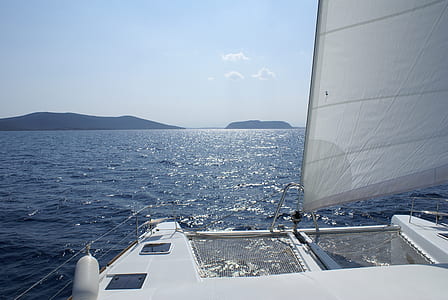 white sail boat on body of water thumbnail