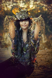shallow focus photography of woman throwing sand during daytime thumbnail