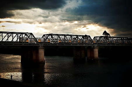 gray train on bridge rail way during daytime thumbnail