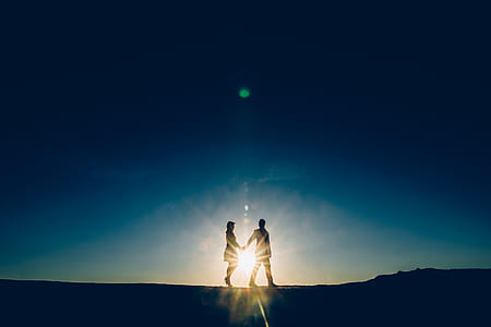 silhouette of couple holding hands while walking thumbnail
