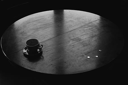 grayscale photography of ceramic teacup on round table thumbnail