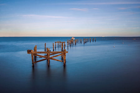 brown wooden poles in body of water thumbnail