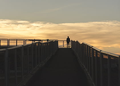 silhouette of man standing on the edge of railings thumbnail
