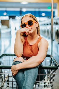 woman in brown tank top sitting on gray shopping cart thumbnail