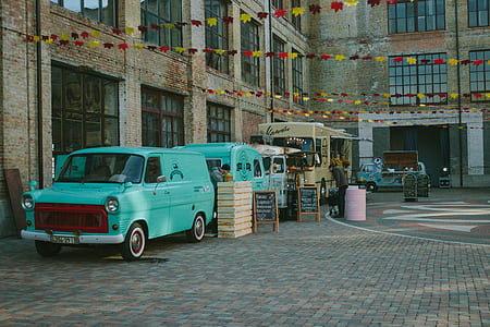 Green Minivan Near Brown Wooden Crate and Brown Food Truck thumbnail