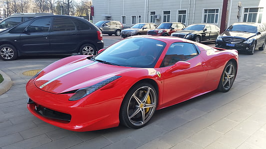 red coupe parked near gray building thumbnail