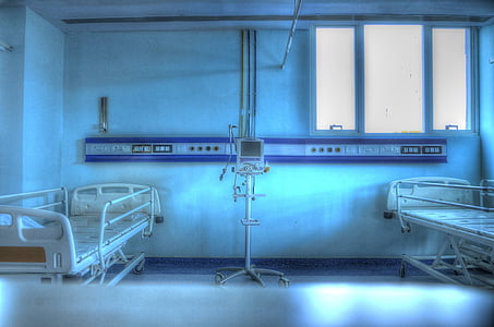 white digital blood pressure monitor placed between hospital beds thumbnail