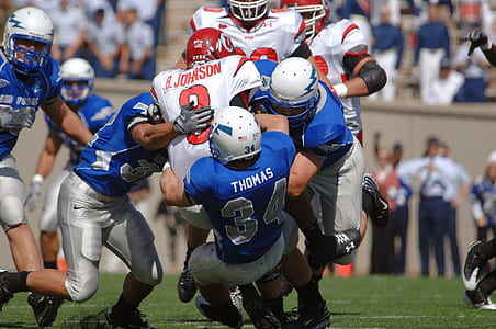 football players holding other player during daytime thumbnail
