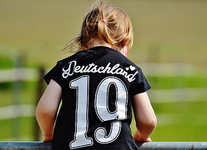 Girl Wearing Deutschland 19 Black T Shirt during Daytime thumbnail
