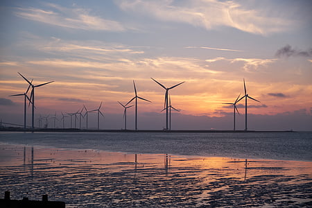 wind turbines near body of water during orange sky thumbnail