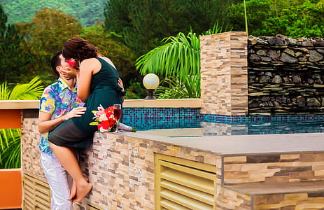 man and woman kissing beside the swimming pool thumbnail