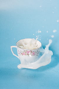 white and pink floral ceramic teacup with white liquid thumbnail