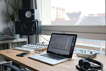 MacBook Pro on table beside headphones thumbnail