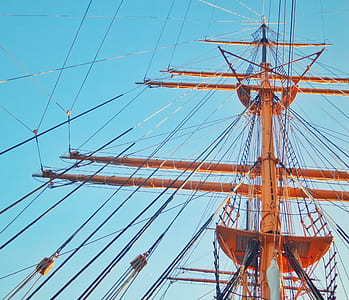 low-angle photo of orange wooden ship mast during daytime thumbnail