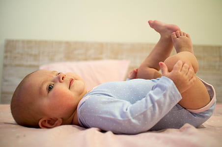 baby lying on pink bed sheet thumbnail