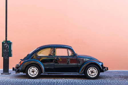 black Volkswagen Beetle coupe parked behind black metal post thumbnail