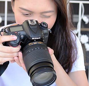 Asian girl takes photo with a Nikon D7200 DSLR camera - Editorial use thumbnail