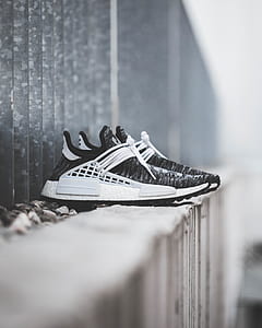 pair of black-and-white adidas NMD shoes on concrete surface thumbnail