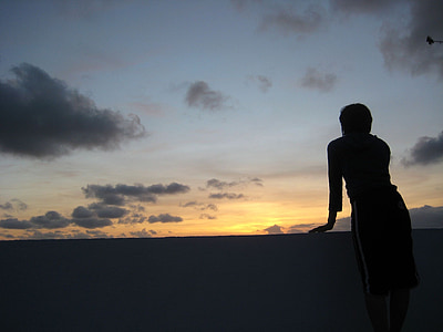 silhouette of person leaning on black handrail thumbnail