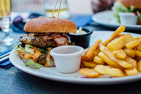 grilled burger patty with buns beside side dish French fries and dips thumbnail