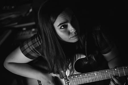 woman playing electric guitar inside studio close-up photography thumbnail
