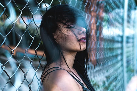 woman leaning on chain-link fence thumbnail
